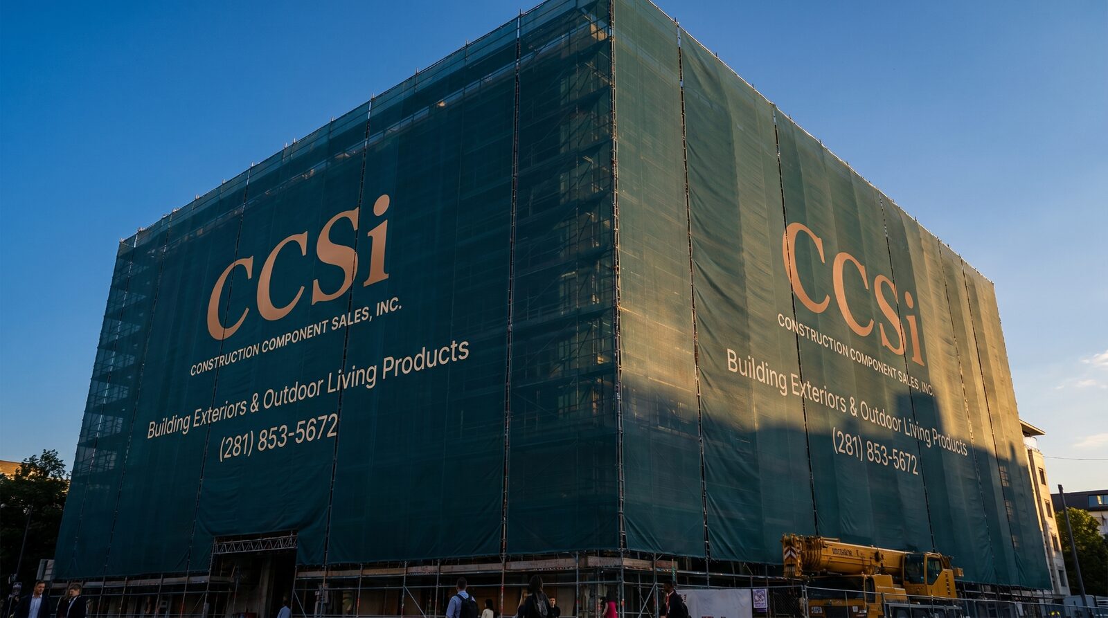 Two-building printed mesh marketing wrap photographed at dusk on an active jobsite